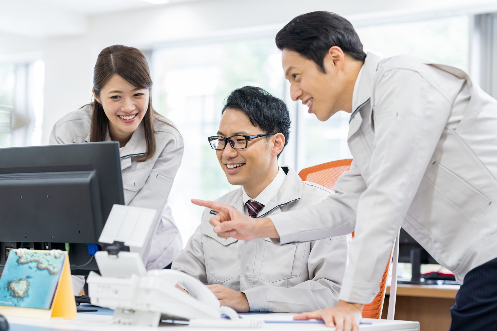 オフィスワークをする作業服の従業員