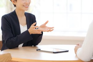 テーブルを挟んで対話する女性2人