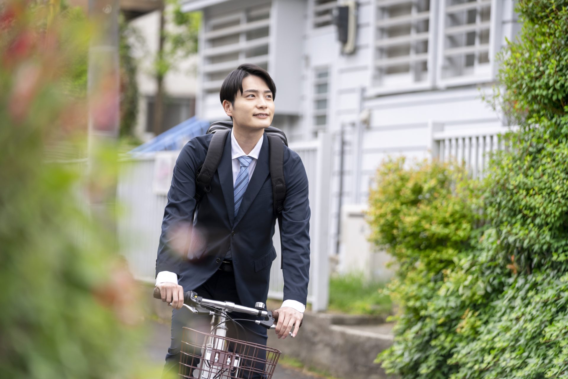 自転車に乗ったスーツ姿の若い男性