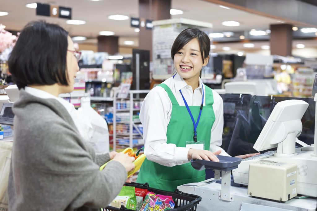 スーパーマーケットで接客中の従業員のイメージ